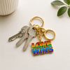 Exklusiver „Love Wins“ Schlüsselanhänger – Regenbogen Pride Edition – Gold-Optik – ProudYou