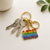 Exklusiver „Love Wins“ Schlüsselanhänger – Regenbogen Pride Edition – Gold-Optik – ProudYou